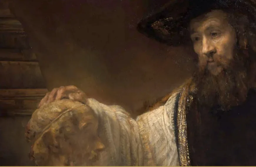 Detail of a Rembrandt painting: a bearded man in a wide black hat and white sleeves rests his hand on a marble bust, shelved books behind him.