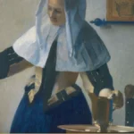 A woman in a white linen cap stands at a leaded window, one hand on the casement and the other on a brass pitcher, a basin and blue cloth on the table before her.