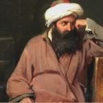 A bearded man in a white turban and a rose-colored robe sits slumped against a wooden chest, his head propped on one hand, beside a plaster bust and a cluttered desk in a dim studio.